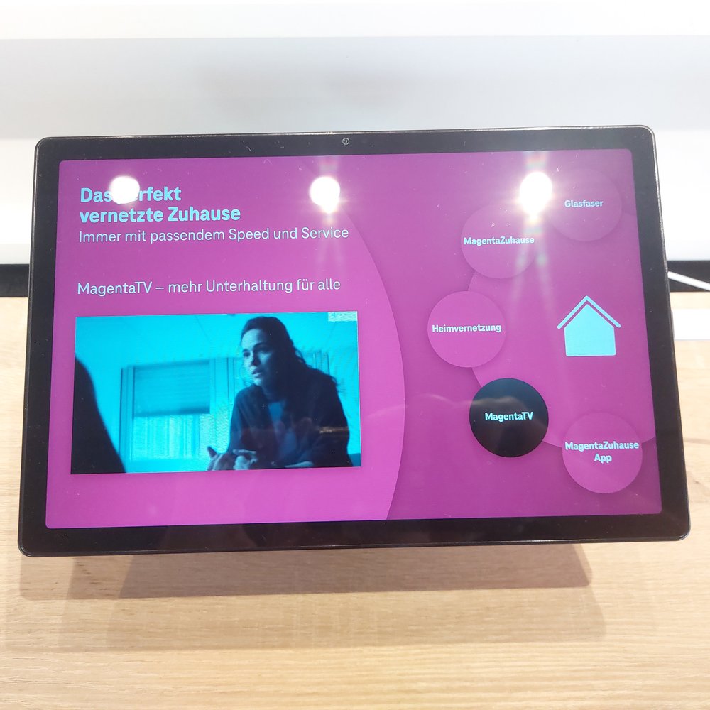 Stand-Bildschirm mit laufendem MagentaTV-Video und dem Menürad der Magenta-Dienste